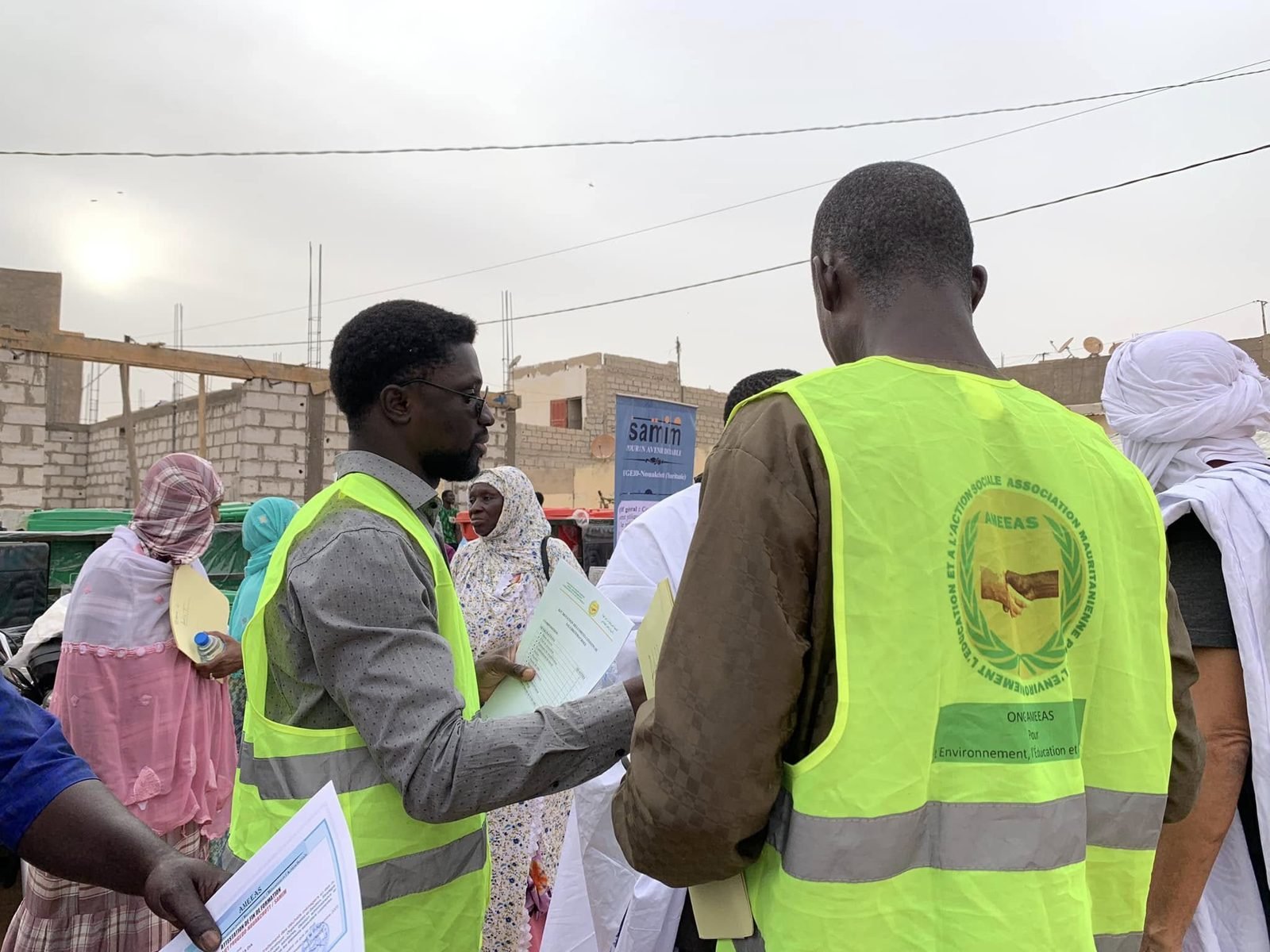 Membres de l'AMEEAS en gilets jaunes distribuant des documents lors d'une action de terrain à Nouakchott