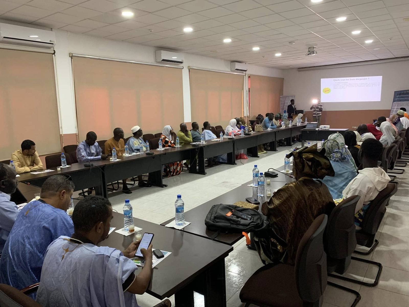 Atelier de présentation d'un projet réuni autour d'une grande table de conférence
